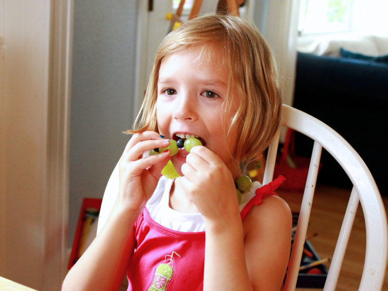child eating fruit necklace