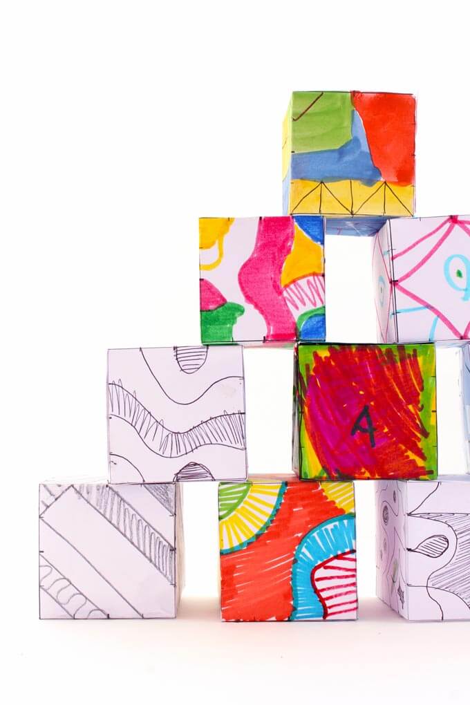 Finished colorful doodle cubes stacked up together.