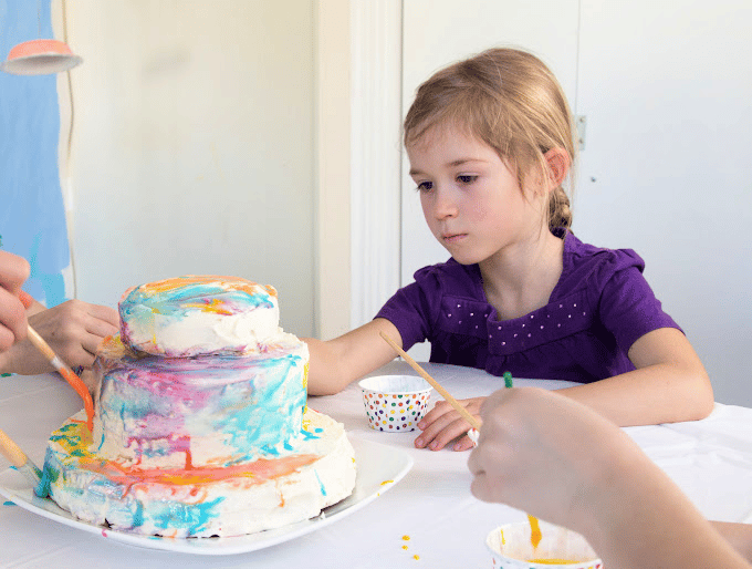 girl painting a cake
