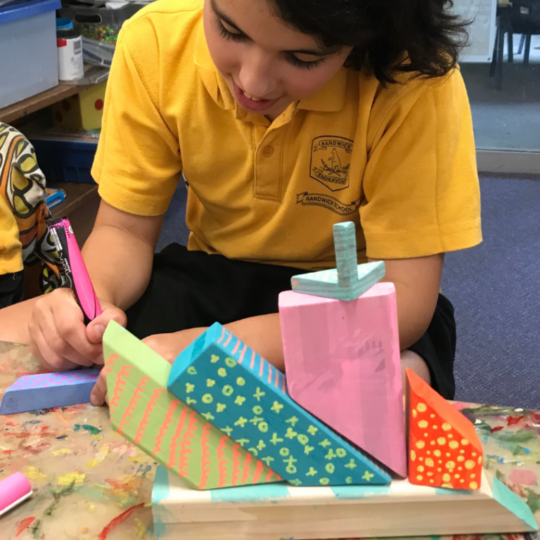 children drawing on wood blocks