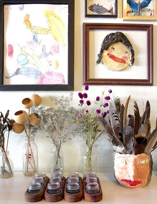 Easy nature drawing ideas for kids – artwork hanging in frames on the wall along with flowers & feather for observational drawing