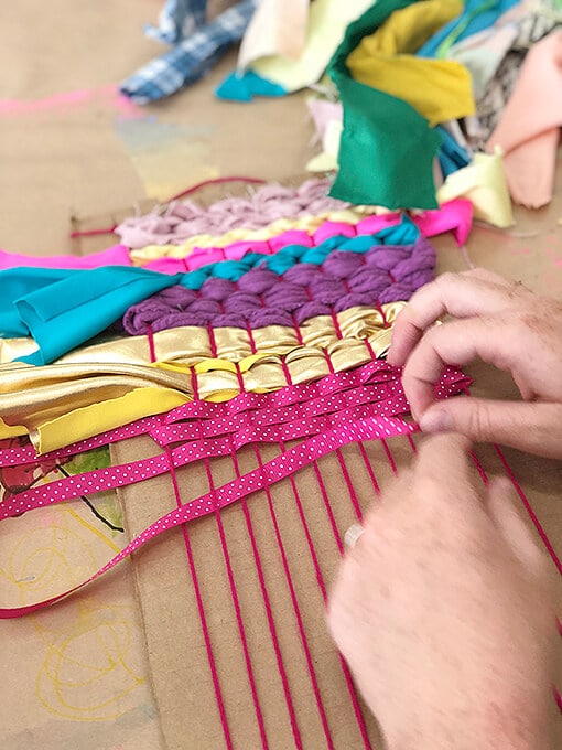Weaving for kids with ribbon and yarn on a cardboard loom
