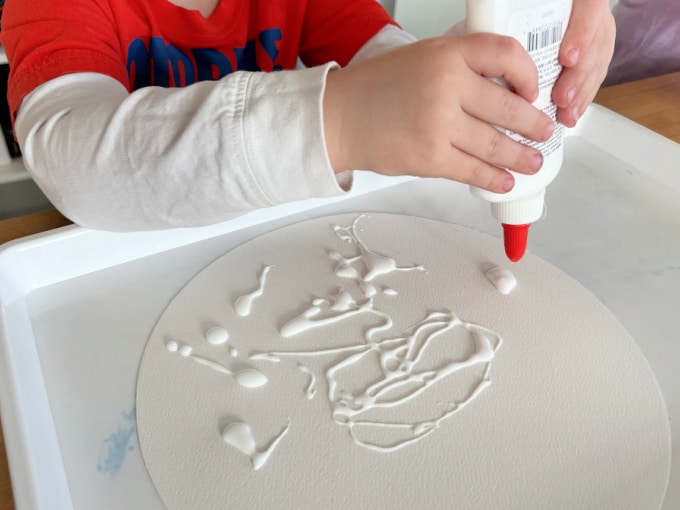 squeezing glue onto paper