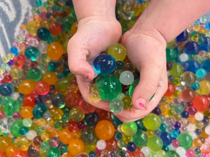 hands scooping water beads
