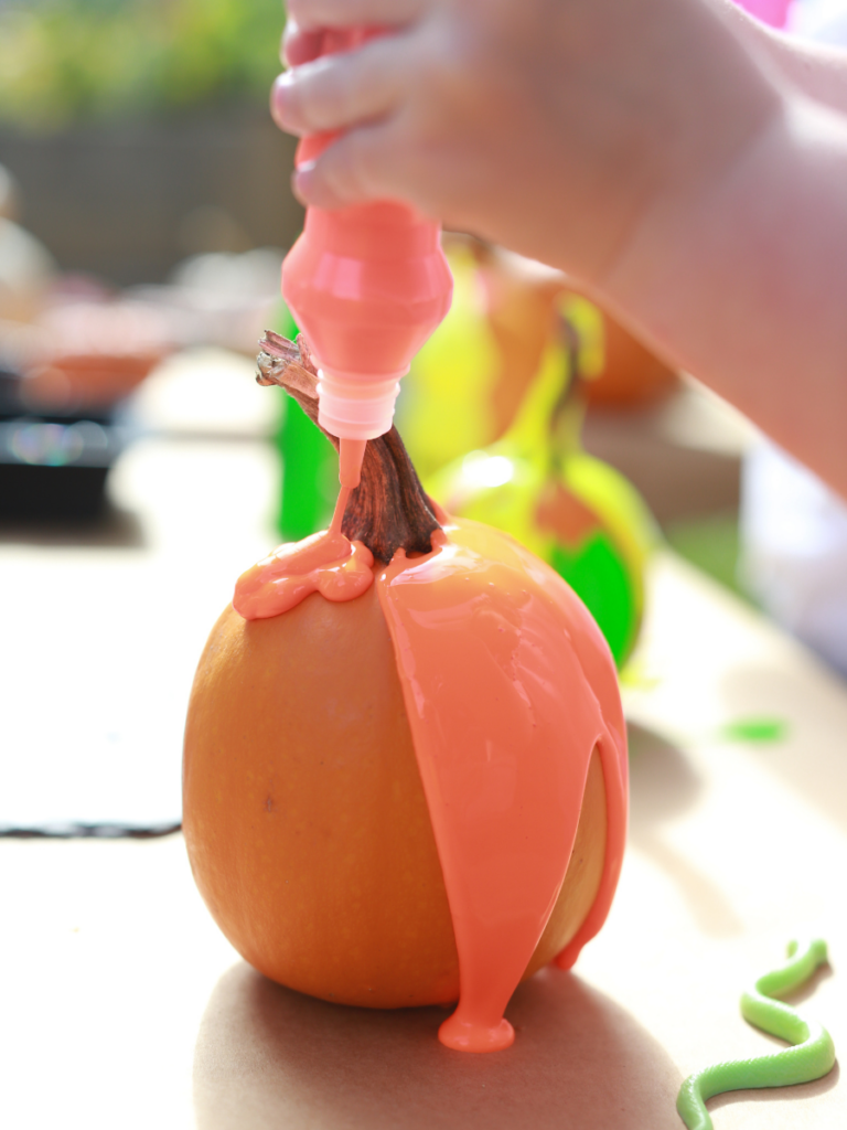 squeezing paint on pumpkins